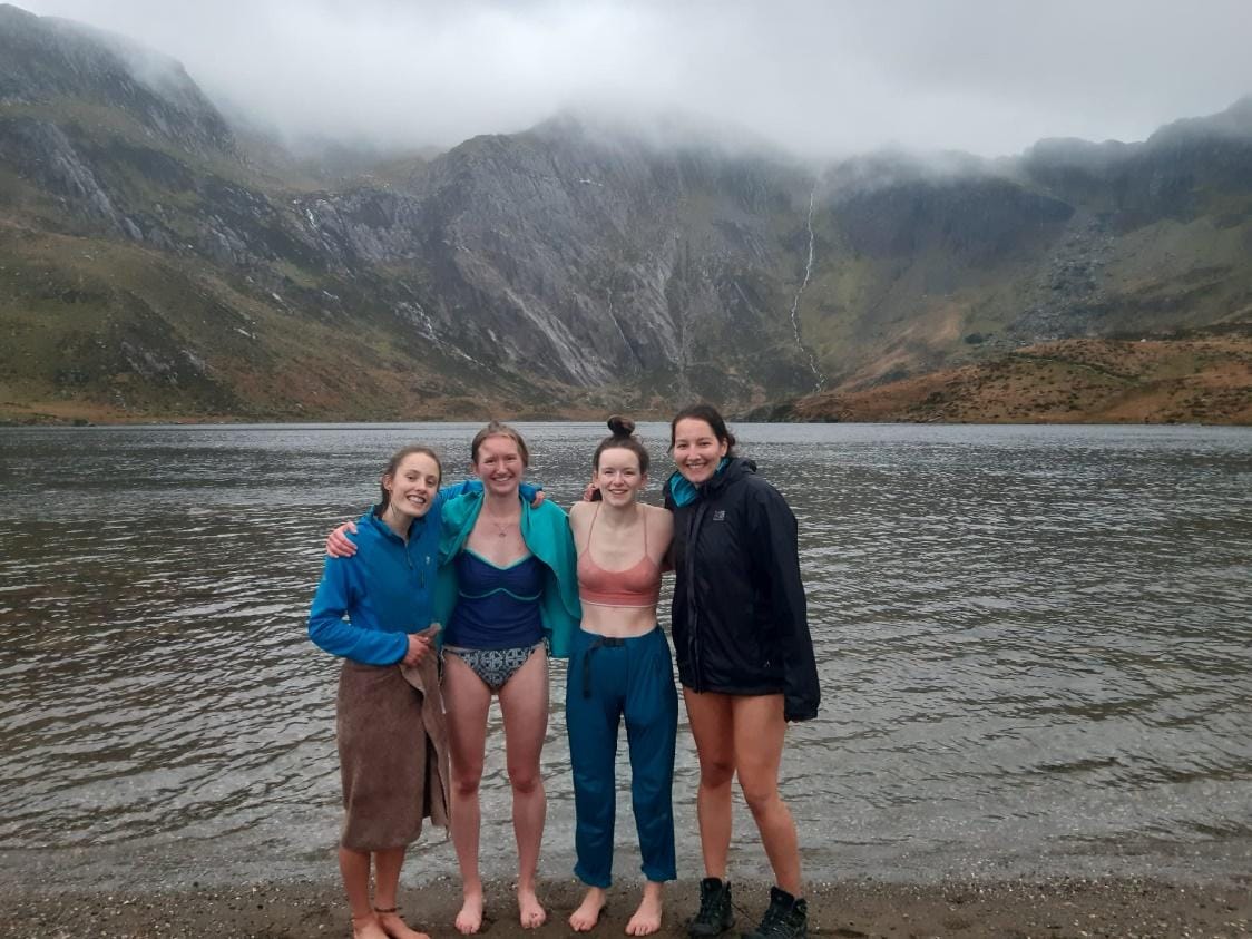 A group of women standing in front of a lake
Description automatically generated with medium confidence